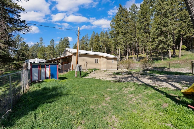 view of yard with fence and an outbuilding