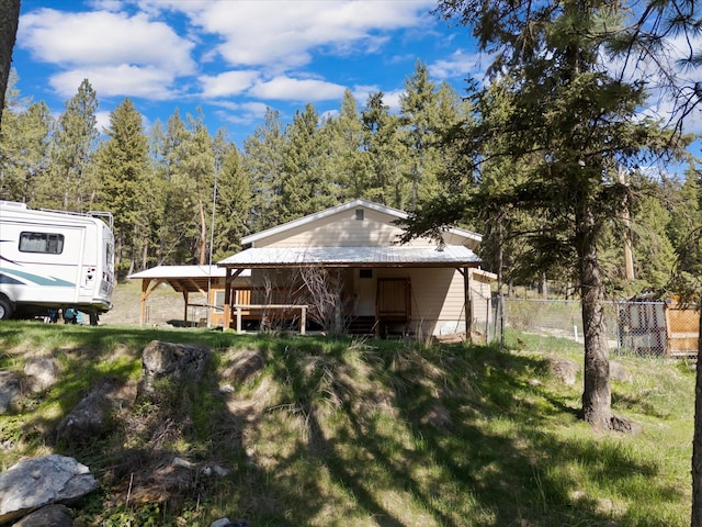 back of property featuring fence and metal roof
