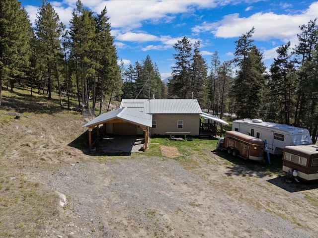 exterior space featuring driveway, metal roof, and a carport