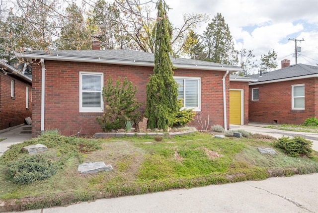 1702 Bancroft St, Missoula, MT 59801 - ranch-style home featuring brick siding, a garage, a chimney, and a shingled roof