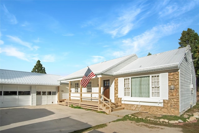 330 Bowman Rd, Hamilton, MT 59840 - ranch-style home with stone siding, covered porch, a metal roof, and a detached garage