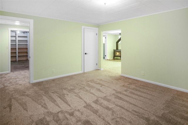 330 Bowman Rd, Hamilton, MT 59840 - empty room featuring a wood stove, carpet floors, and crown molding