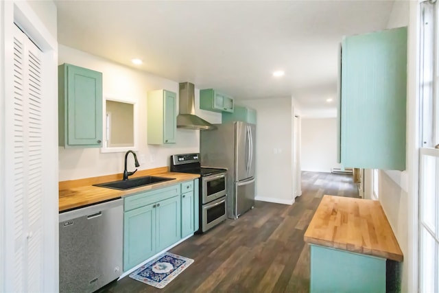 330 Bowman Rd, Hamilton, MT 59840 - kitchen with appliances with stainless steel finishes, wooden counters, wall chimney range hood, dark wood-style floors, and recessed lighting