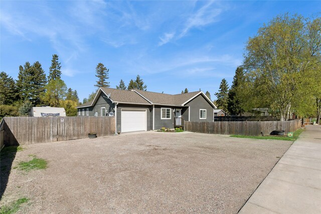 1020 3rd Ave E, Columbia Falls, MT 59912 - single story home with an attached garage, fence private yard, roof with shingles, and aphalt driveway