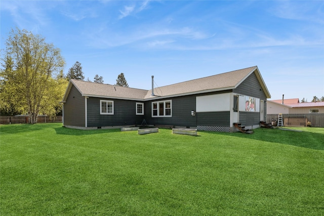 1020 3rd Ave E, Columbia Falls, MT 59912 - rear view of house featuring a lawn, a fenced backyard, and entry steps