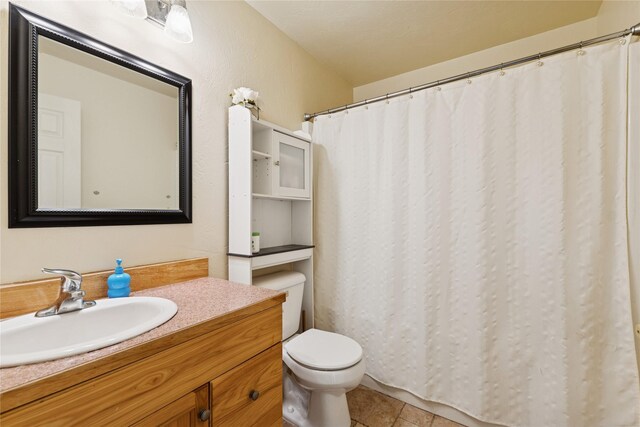 1020 3rd Ave E, Columbia Falls, MT 59912 - bathroom with toilet, tile patterned flooring, and vanity