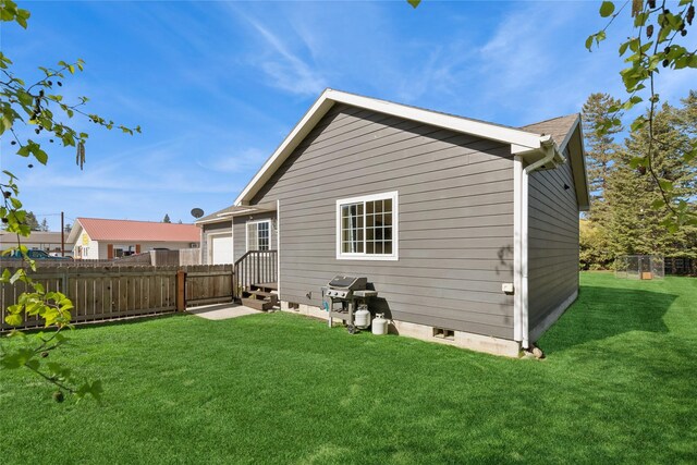 1020 3rd Ave E, Columbia Falls, MT 59912 - rear view of house with fence and a lawn