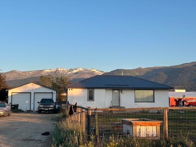2421 Clark St, Victor, MT 59875 - single story home with a mountain view, a detached garage, stucco siding, a metal roof, and an outbuilding