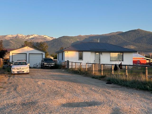 2421 Clark St, Victor, MT 59875 - ranch-style home featuring a detached garage, a mountain view, and an outbuilding