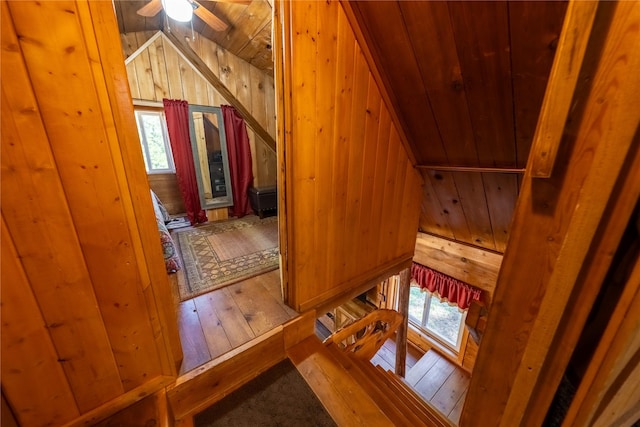 interior space with wooden walls, wood ceiling, wood-type flooring, and vaulted ceiling