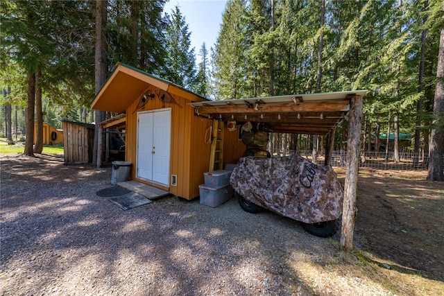view of shed with fence and a carport