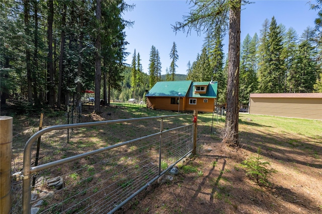 view of yard featuring fence, an outbuilding, and a gate