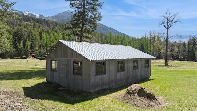 view of outbuilding with a mountain view and a forest view