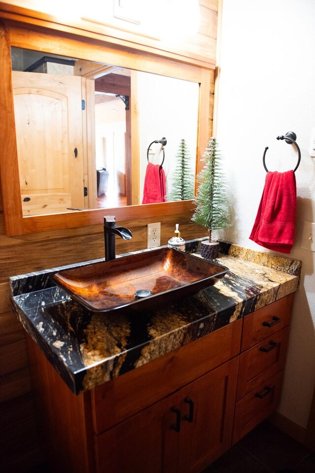 kitchen featuring dark stone counters, wood finished floors, wooden ceiling, high end stove, and pendant lighting