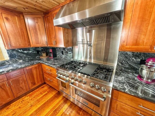 kitchen featuring wood ceiling, brown cabinetry, pendant lighting, built in refrigerator, and light wood-type flooring