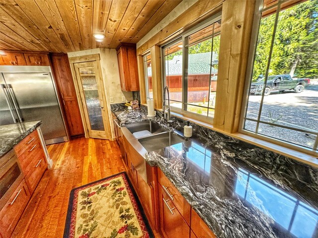 dining space featuring baseboards, light wood-type flooring, and wooden ceiling