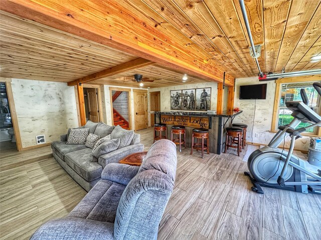 living area featuring a wood stove, light wood-style floors, and baseboards
