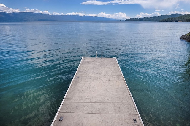 view of dock with a water and mountain view