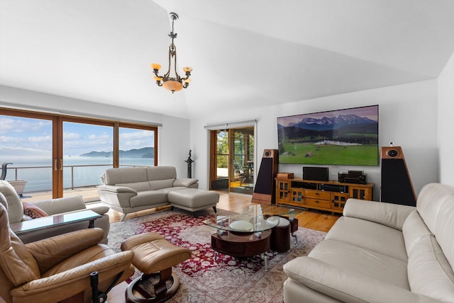 living area with vaulted ceiling, a notable chandelier, and wood finished floors