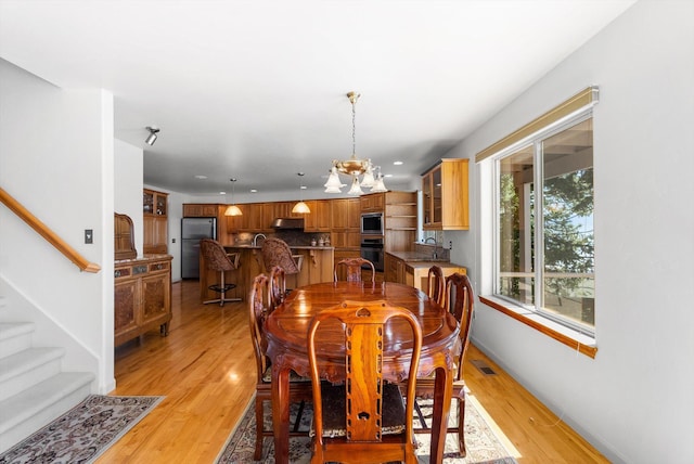 dining area featuring stairs, recessed lighting, a notable chandelier, baseboards, and light wood-style floors