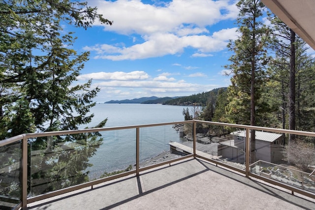 balcony featuring a water and mountain view