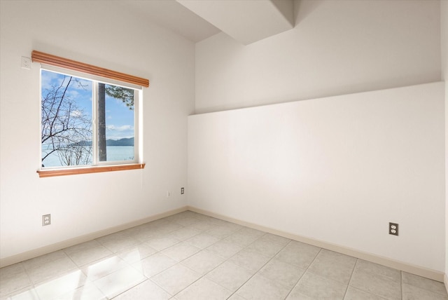 empty room featuring light tile patterned floors and baseboards