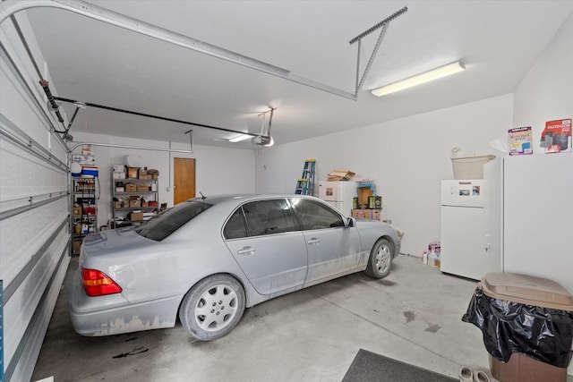 garage featuring freestanding refrigerator and a garage door opener
