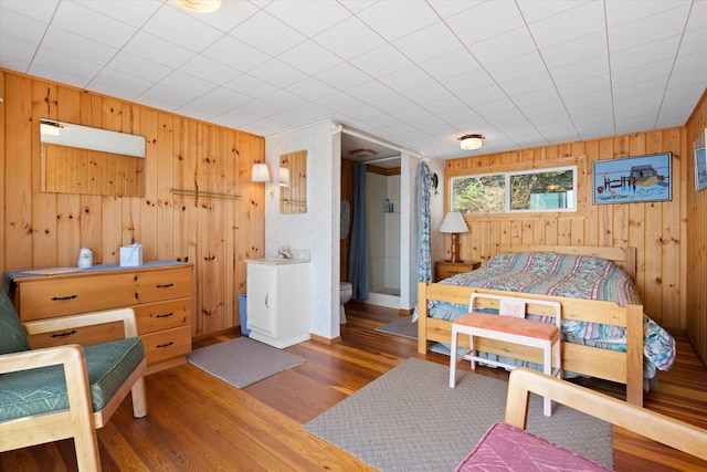 bedroom with wood walls and wood finished floors