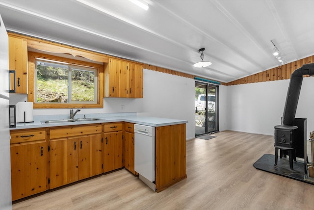 kitchen featuring white dishwasher, a sink, vaulted ceiling, light wood-style floors, and light countertops