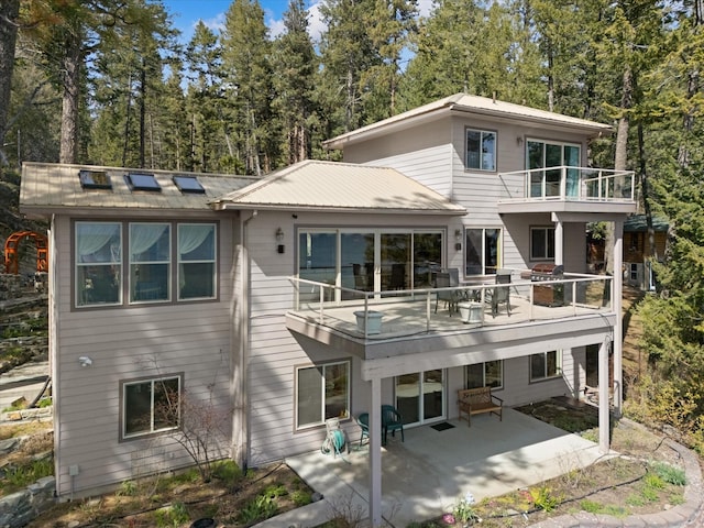 back of house featuring a balcony and a patio