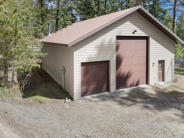 detached garage featuring fence