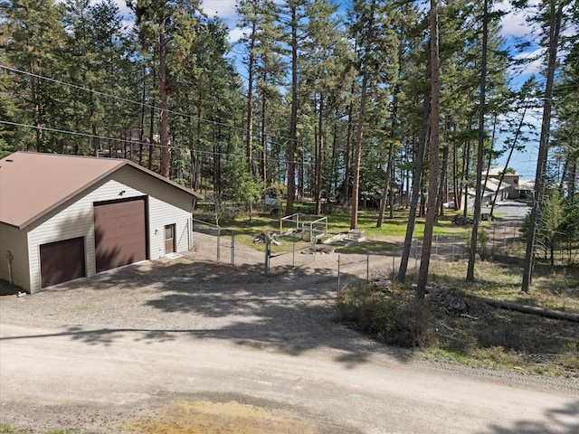 exterior space with an outbuilding, a gate, fence, and a garage
