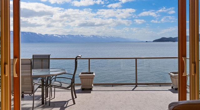 balcony featuring a water and mountain view