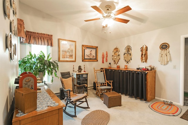sitting room featuring light colored carpet, baseboards, and a ceiling fan