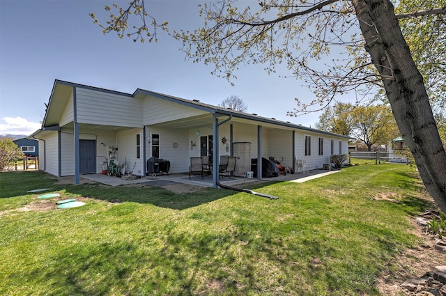 rear view of house featuring fence, a patio, and a lawn