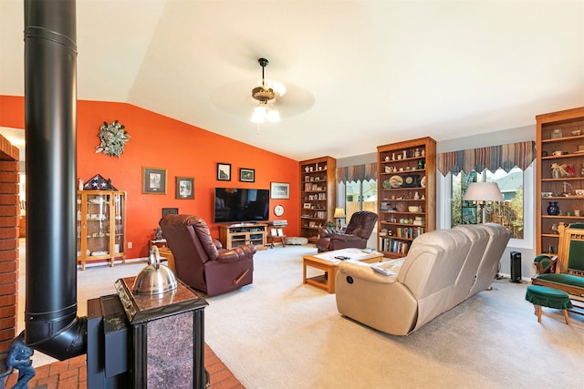 carpeted living area with lofted ceiling, a wood stove, and ceiling fan