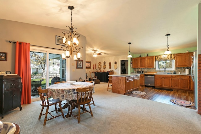 dining space with plenty of natural light, dark colored carpet, and a notable chandelier