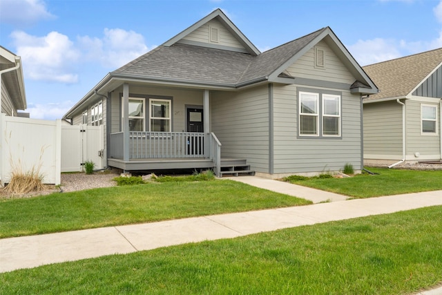 2421 Half Hitch Dr, Missoula, MT 59808 - view of front of property featuring a porch, fence, a shingled roof, and a front lawn