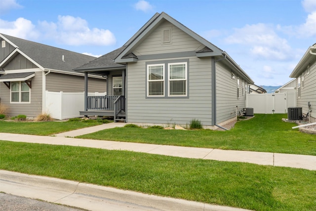 2421 Half Hitch Dr, Missoula, MT 59808 - view of front of house featuring cooling unit, roof with shingles, a front lawn, and fence