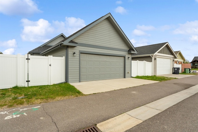 2421 Half Hitch Dr, Missoula, MT 59808 - view of front of property featuring a gate, fence, a garage, board and batten siding, and a shingled roof