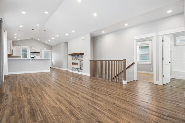2421 Half Hitch Dr, Missoula, MT 59808 - unfurnished living room featuring dark wood finished floors, vaulted ceiling, baseboards, and recessed lighting