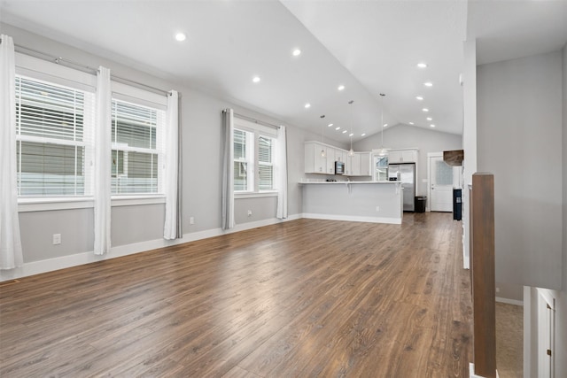 2421 Half Hitch Dr, Missoula, MT 59808 - unfurnished living room featuring baseboards, dark wood-style flooring, recessed lighting, and vaulted ceiling