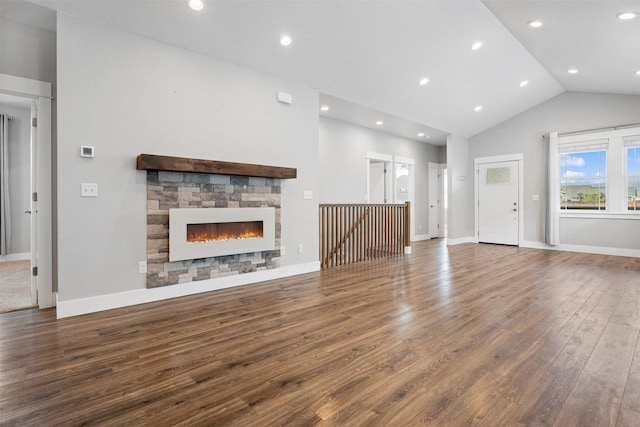 2421 Half Hitch Dr, Missoula, MT 59808 - unfurnished living room featuring wood finished floors, baseboards, a stone fireplace, lofted ceiling, and recessed lighting