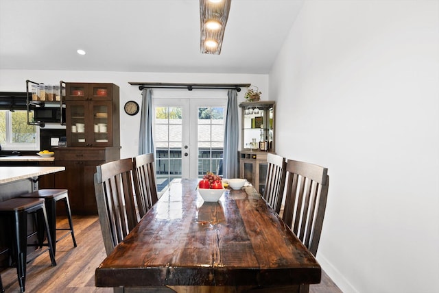 dining area featuring wood finished floors, french doors, and baseboards