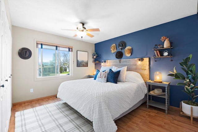 bedroom with wood finished floors, baseboards, and ceiling fan