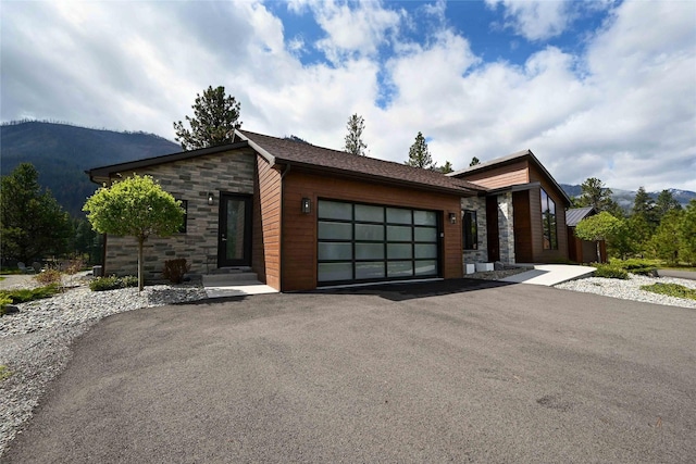 2 Mahonia Ct, Plains, MT 59859 - view of front facade with stone siding, a mountain view, driveway, and a garage