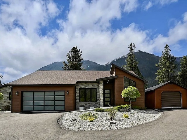 2 Mahonia Ct, Plains, MT 59859 - contemporary home with stone siding, a mountain view, and driveway