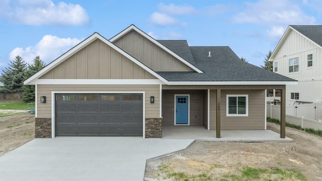 craftsman inspired home with a porch, stone siding, driveway, a garage, and board and batten siding
