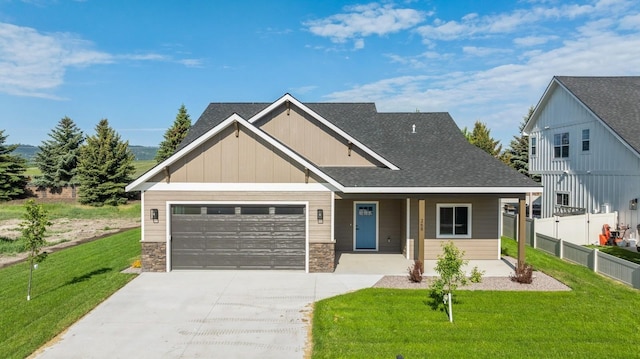 268 Landing Ln, Kalispell, MT 59901 - craftsman house featuring driveway, an attached garage, stone siding, covered porch, and board and batten siding