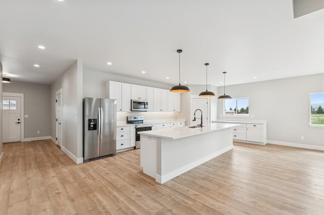 kitchen featuring light wood-style floors, light countertops, plenty of natural light, and appliances with stainless steel finishes